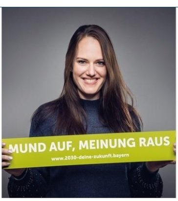 Frau hält Banner mit dem Text "Mund auf, Meinung raus"