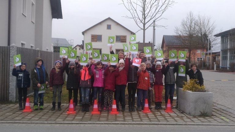 Gruppenfoto bei dem die Schüler der dritten Klasse den vorbildlichen Autofahrern Schilder mit einem grünen Daumen zeigen