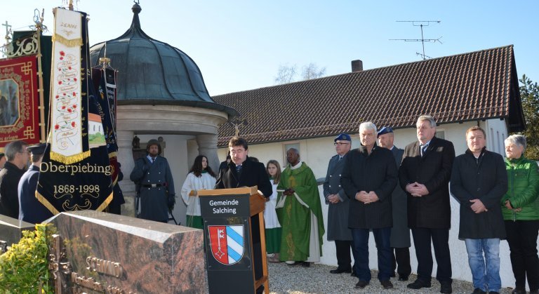 Bürgermeister Alfons Neumeier bei seiner Ansprache am Kriegerdenkmal, im Hintergrund Pfarrer Dr.Raphael Mabaka und die Vertreter der Bundeswehr und der Gemeinde Salching