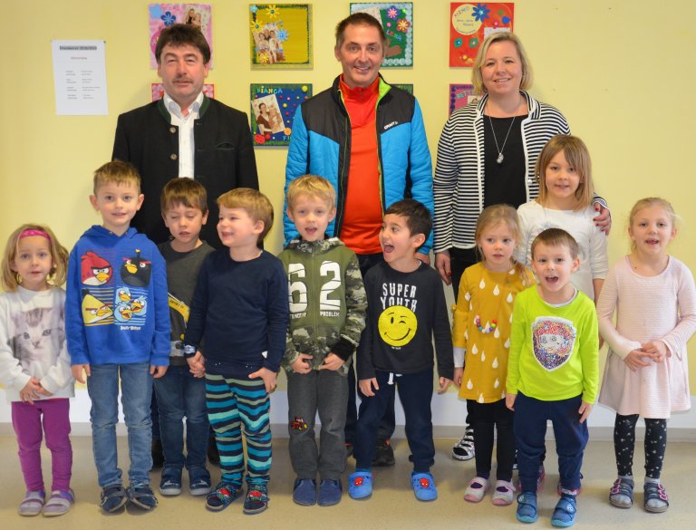 Bürgermeister Alfons Neumeier, Geschäftsführer Thomas Mayr und Kita-Leiterin Andrea Legerer, sowie die Kinder freuen sich über neues Baumaterial