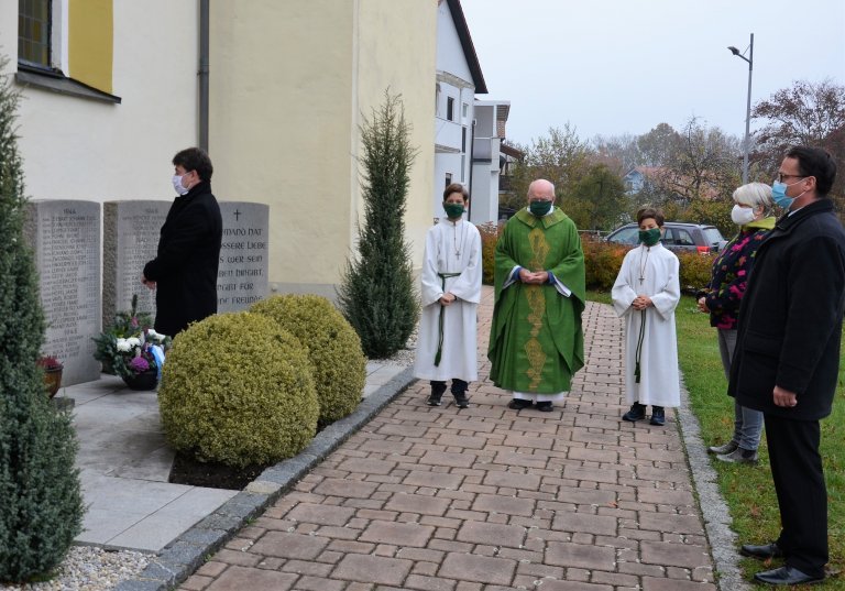 Pfarrer Ludwig Bumes und zwei Ministranten bei der Kranzniederlegung in Salching