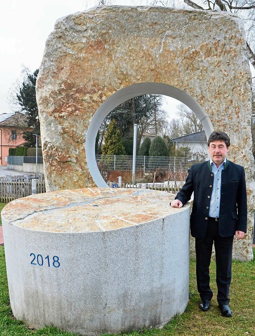 Bürgermeister Alfons Neumeier vor dem Kunstwerk, das beim Schaugarten aufgestellt wurde. Es symbolisiert einen Mühlstein, und die einstigen Mühlen entlang der Aitrach sind darauf eingezeichnet. Foto: Josef Bierl