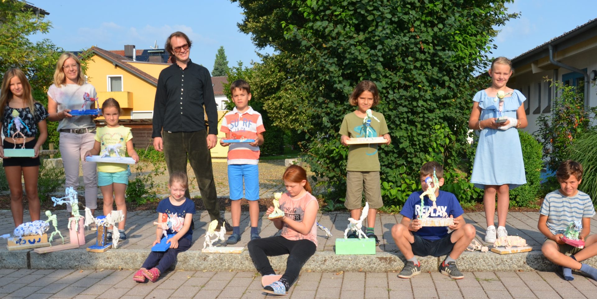 Abordnungen der vier Grundschulklassen mit Lehrerin Anita Burhenne (Zweite von links) und Künstler Peter Herr präsentieren ihre Werke. Foto: Josef Bierl